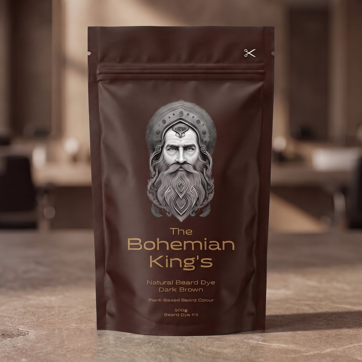 A stand-up pouch of beard dye standing on a stone-like surface with a blurred indoor background. The package is dark brown with a large silver-gray illustrated face and the text 'The Bohemian King's' and 'Natural Beard Dye Dark Brown'.