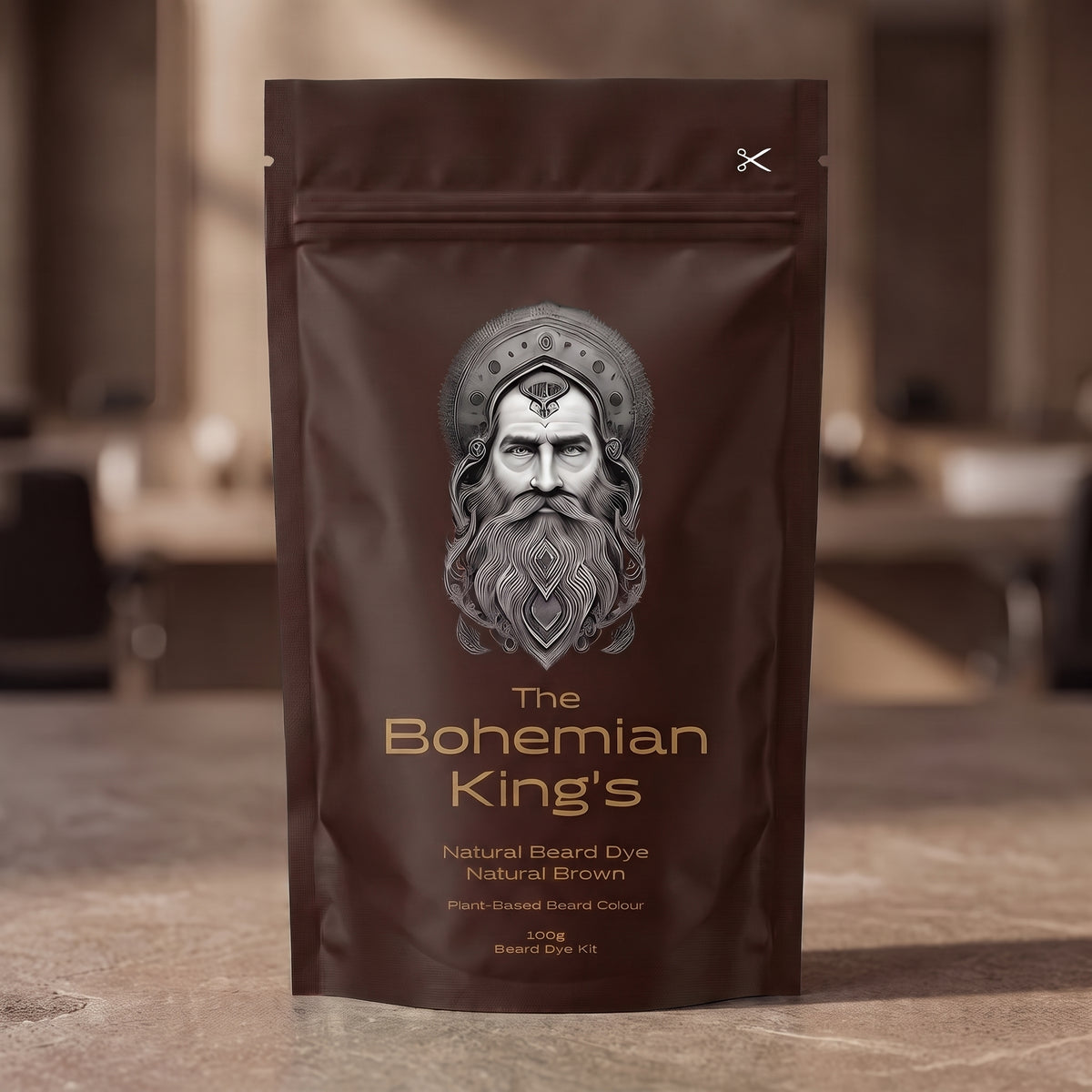 A stand-up pouch of beard dye standing on a stone-like surface with a blurred indoor background. The package is dark brown with a large silver-gray illustrated face and gold text reading 'The Bohemian King's' and 'Natural Beard Dye Natural Brown.